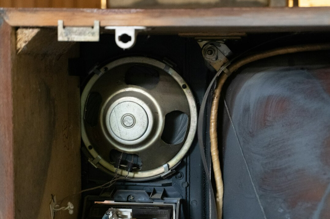 Close-up of an old speaker inside a wooden cabinet
