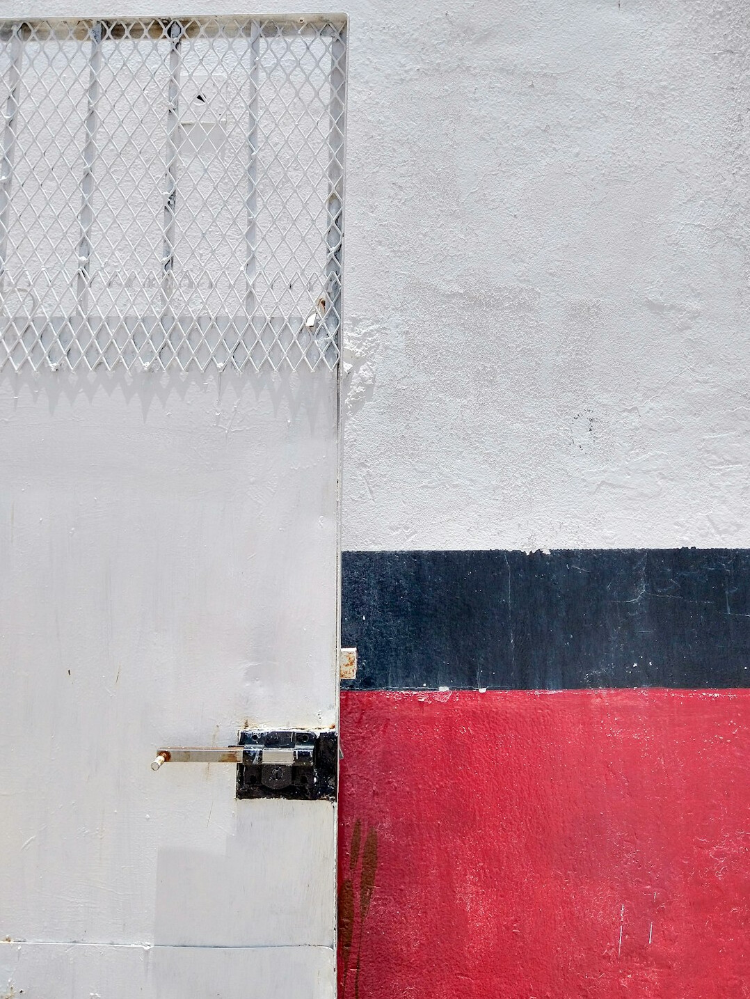 A camera set up in front of a red and white wall