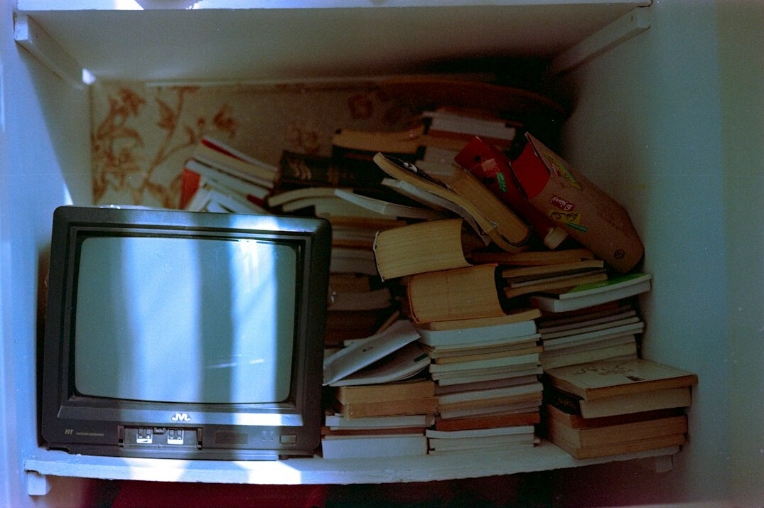A pile of books and a TV sitting on top of a table
